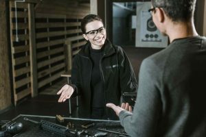 Enhancing customer experience in a gun store.  The gun store owner is showing a customer a firearm on the counter. 