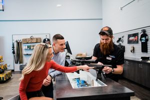 Staff shows couple shopping for guns promotions from firearm retailers holiday prep.