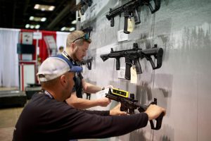 Two employees revamping a display for their firearm retailers holiday prep.