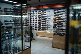 Gun store display room featuring wall-mounted rifles and glass cases of gun accessories, using shooting range management software with Gun Store POS Security